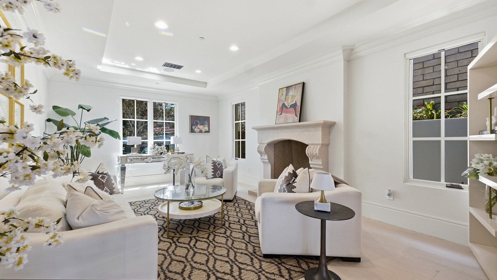The living room, with a fireplace and tall windows.