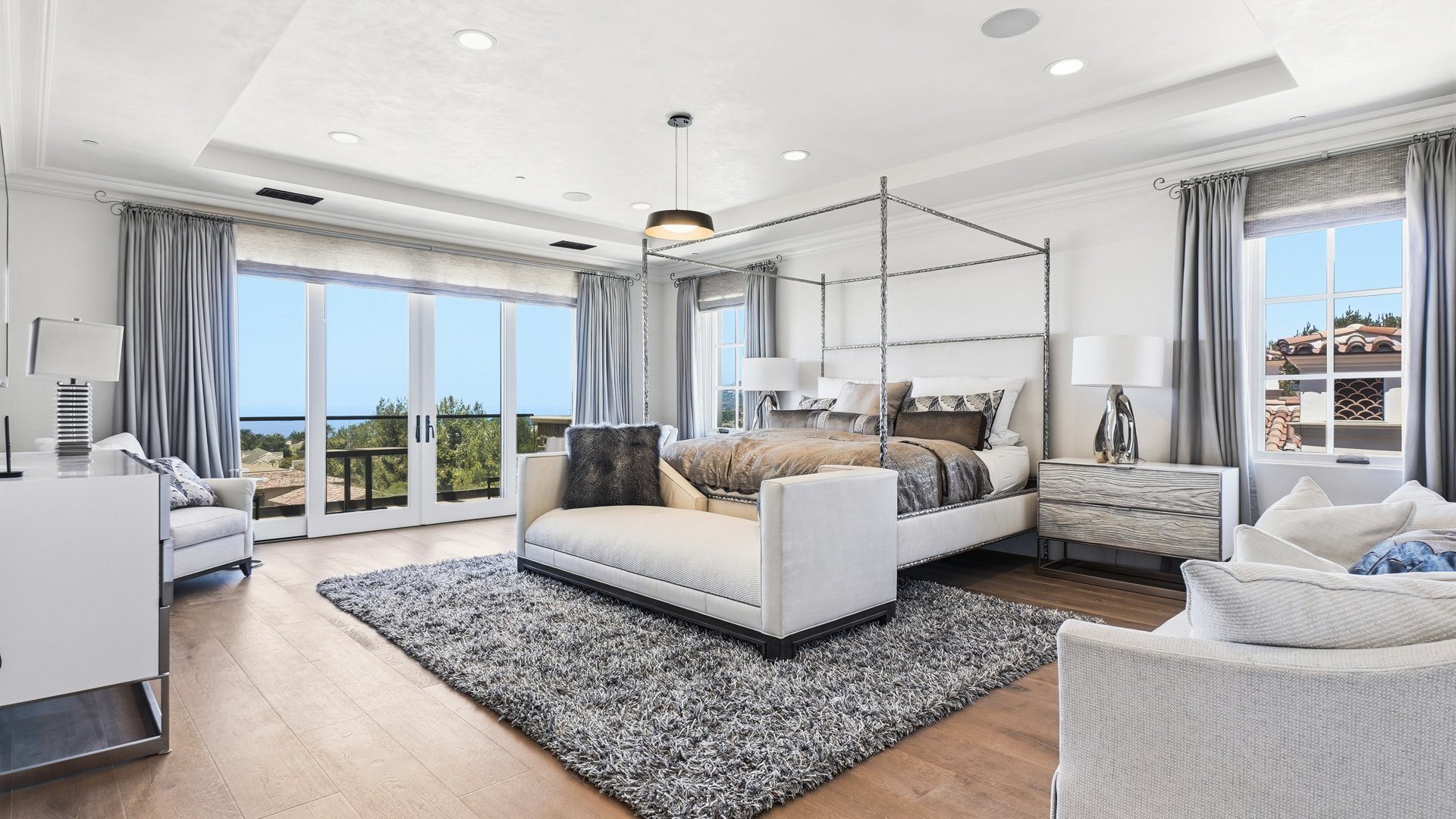 The primary bedroom, with French doors open to the view.