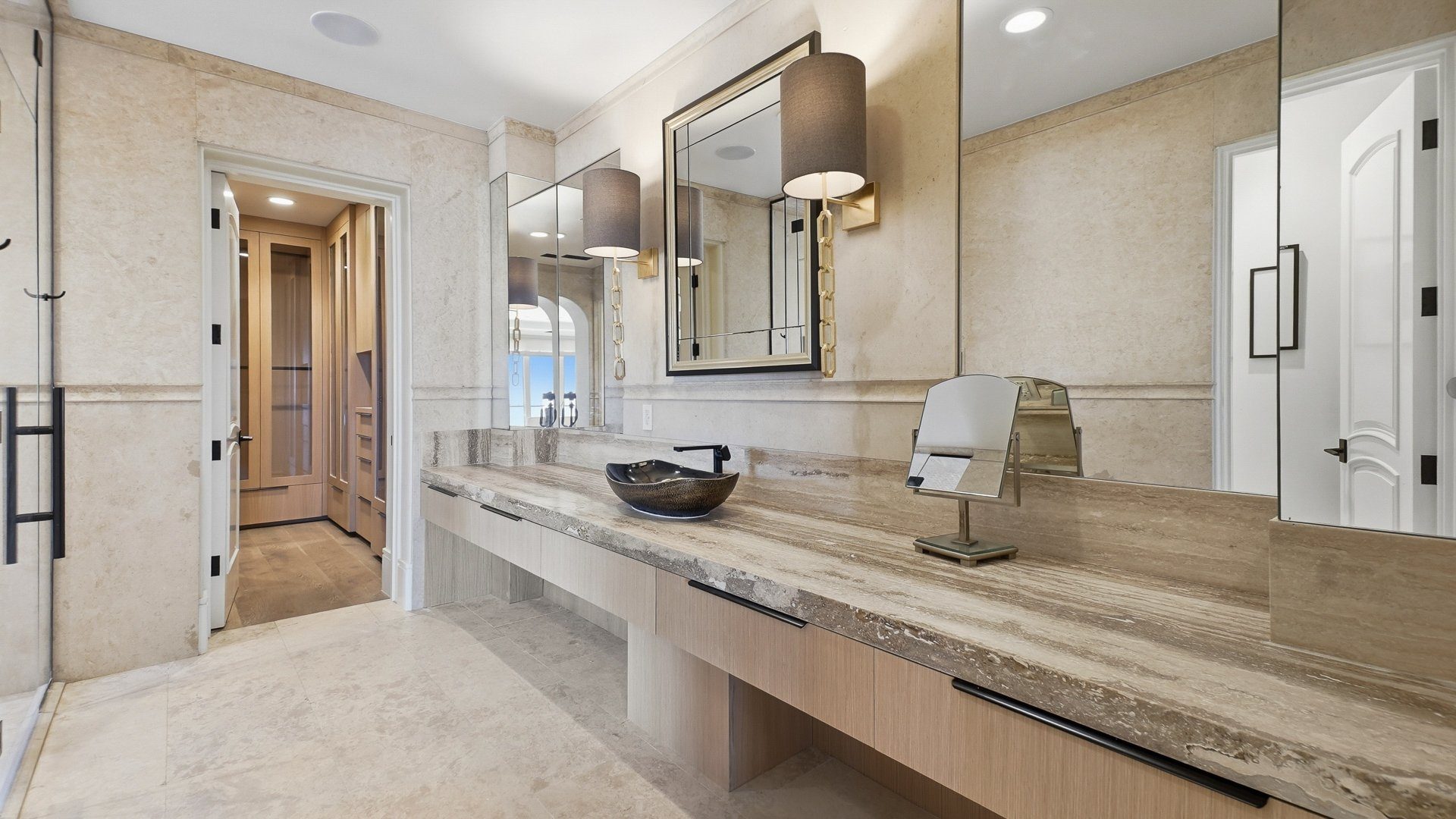 The primary bath vanity in travertine and oak.