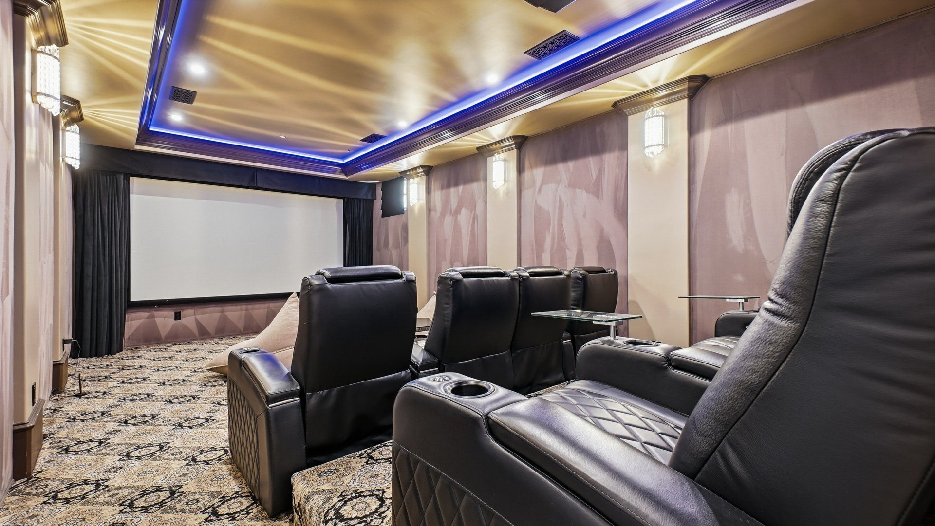 The theater, with tiered leather recliners facing the screen.