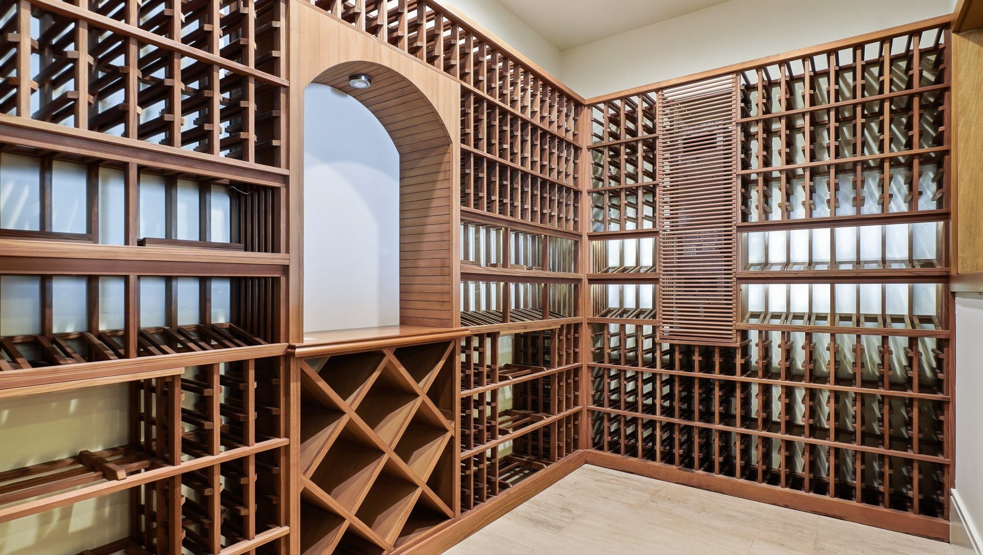 The wine room, floor to ceiling racks in wood with an arched display.