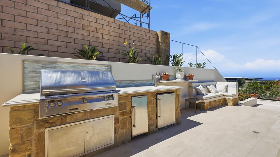 The outdoor kitchen with a built-in grill.
